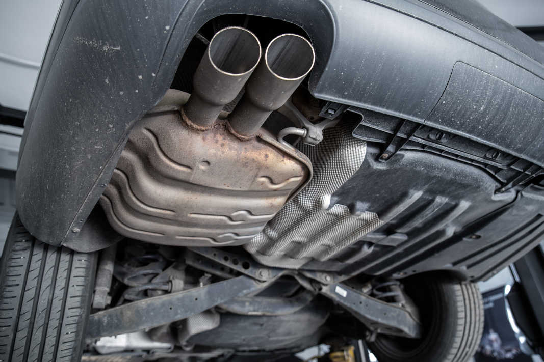 Exhaust System Inspection for Repair Close-up of a car's exhaust system and muffler during a professional inspection and repair at Pulaski Automotive in Chicago.