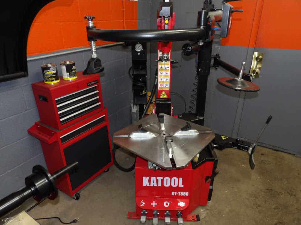 MINOLTA DIGITAL STILL CAMERA Katool KT-T850 tire changer alongside a red tool station at Pulaski Automotive, showcasing advanced equipment for tire services in Chicago.