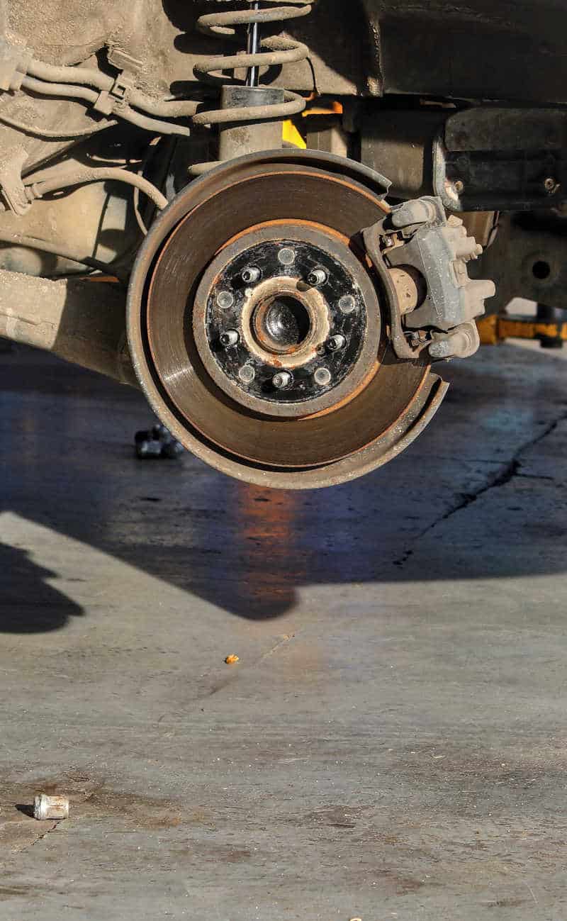 Worn Brake Rotor and Pad – Auto Repair in Chicago Close-up of a car's worn brake rotor and caliper assembly during brake inspection at a Chicago auto repair shop